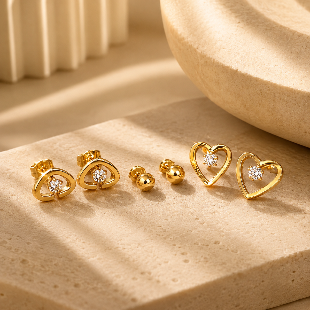 Celestine Studs by JouJule, gold-tone heart-shaped stud earrings with luminous center accents